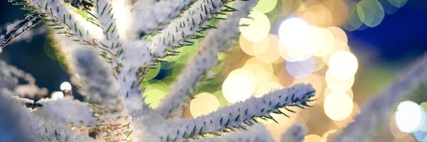 árvore de natal coberta de neve com luzes de guirlandas amarelas e espaço de cópia bokeh com bokeh brilhante foto