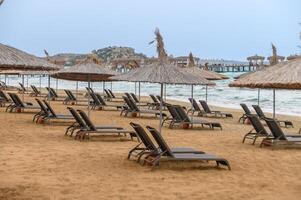 banhistas com guarda-chuvas em a de praia do a Mediterrâneo mar 5 foto