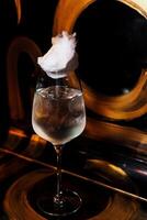 alcoólico bebida. uma coquetel com elite álcool em Sombrio Preto fundo foto