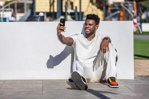 homem sentado em a terra levando uma selfie foto