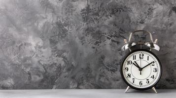 clássico alarme relógio em texturizado fundo. clássico Preto e branco alarme relógio em pé em uma texturizado cinzento concreto fundo, simbolizando Tempo e urgência. foto