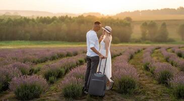 sorridente jovem casal abraçando às a lavanda campo, segurando mãos, andando. foto