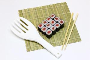 Sushi Entrega. conjunto do rolos dentro uma descartável caixa em uma Preto fundo. topo Visão foto