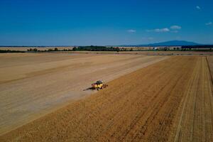 combinar colheitadeira trabalhando dentro agrícola campo. colheita estação foto