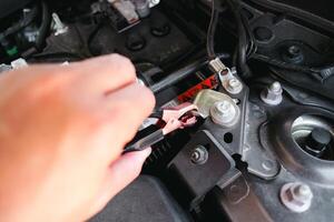 mecânico mão aperto negativo terminal cabo braçadeira para carro corpo , carro manutenção conceito foto