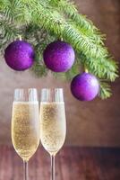 dois óculos do champanhe com Natal árvore ramo foto