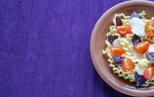 fusilli lunghi com queijo e tomate cereja foto