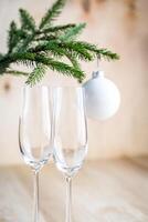Natal árvore ramo com esvaziar champanhe óculos foto