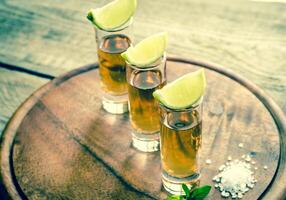 copos de tequila na placa de madeira foto