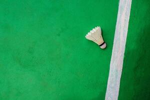 topo visualizar. branco badminton peteca com uma branco listra em a verde chão em a certo. foto