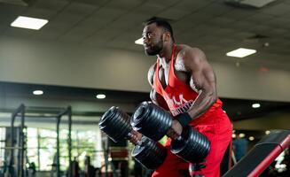 musculação homem exercite-se com halteres. muscular Preto cara Treinamento Difícil dentro academia. foto