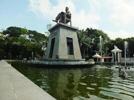 surakarta, central Java, Indonésia abril 11, 2024. a estátua do Sr soekarno sentado enquanto lendo uma livro, estátua do a primeiro Presidente do a republik Indonésia às manahan estádio. foto