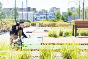 fofa pequeno menina em uma miniatura golfe curso. foto