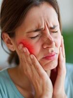 uma mulher detém dela bochecha enquanto sofrimento a partir de uma dor de dente, representando a desconforto e dor com experiência durante dental problemas, enfatizando a precisar para oral saúde Cuidado e tratamento foto