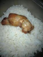 uma peça do frango pescoço e perfumado arroz dentro uma caixa foto