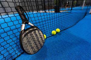 remo tênis raquete e bolas em a azul remo quadra foto