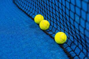 bolas perto a internet do uma azul padel tênis quadra foto