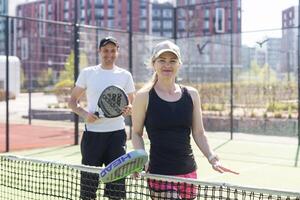 Ucrânia Kyiv, abril 02 2024. jovem mulher e homem falando para cada de outros depois de jogando padel, caminhando ao longo a internet juntos foto