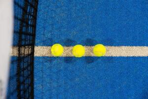 bolas perto a internet do uma azul padel tênis quadra foto