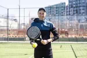 homem jogando padel dentro uma verde Relva padel quadra interior atrás a internet foto