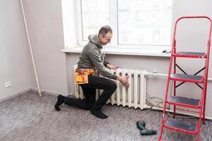 trabalhador substitui doméstico radiador dentro a vivo quarto foto