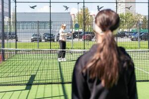 mãe e filha jogando padel ao ar livre foto