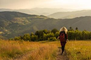 mulher mochileiro apreciar a Visão às montanha foto