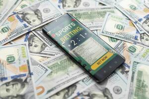 Esportes apostando local na rede Internet dentro uma Móvel telefone tela, dinheiro foto