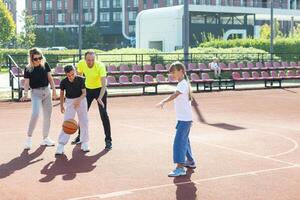 família jogando basquetebol em quadra foto