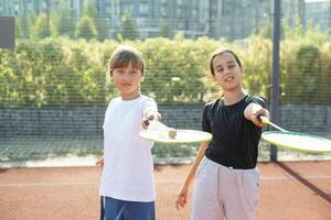 feliz desportivo elementar escola era garota, criança jogando badminton, segurando uma raquete fazer engraçado rostos, retrato, estilo de vida. Esportes, exercício e saudável ao ar livre Atividades lazer conceito, 1 pessoa foto