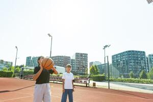 conceito do Esportes, hobbies e saudável estilo de vida. jovem pessoas jogando basquetebol em Parque infantil ao ar livre foto