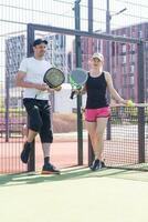 jovem desportivo mulher e homem jogando padel juntos em mesmo equipe foto