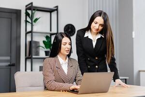 ligar Centro agente com fone de ouvido trabalhando em Apoio, suporte linha direta dentro moderno escritório. dois jovem atraente mulheres estão trabalhando dentro a escritório foto