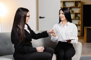 lindo mulher e amigáveis corretor de imóveis fazer real Estado acordo depois de assinatura venda compra acordo ou aluguel contrato. foto