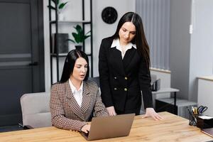 ligar Centro agente com fone de ouvido trabalhando em Apoio, suporte linha direta dentro moderno escritório. dois jovem atraente mulheres estão trabalhando dentro a escritório foto