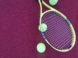 amarelo tênis bolas e raquete em Difícil tênis quadra superfície, topo Visão tênis cena foto