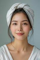 lindo jovem Aisan mulher com toalha em dela cabeça foto