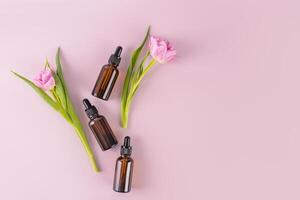 três Sombrio vidro garrafas com uma conta-gotas com uma Cosmético produtos para diariamente autocuidados. natural cosméticos. topo visualizar. plano deitar. uma cópia de espaço. foto