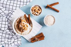 arroz pudim com canela e castanha de caju dentro uma tigela em a mesa topo Visão foto