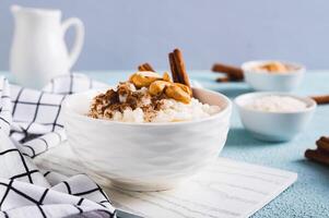 arroz pudim com canela e castanha de caju dentro uma tigela em a mesa foto