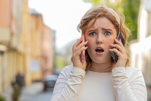 irritado estressado o negócio mulher falando em dois Móvel telefones tendo conversação conflito brigar foto