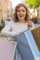 feliz jovem mulher viciado em compras consumidor depois de compras venda com cheio bolsas caminhando dentro cidade Cidade rua foto