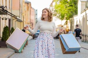 feliz jovem mulher viciado em compras consumidor depois de compras venda com cheio bolsas caminhando dentro cidade Cidade rua foto