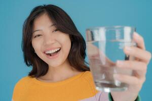 alegre mulher segurando uma vidro do água foto