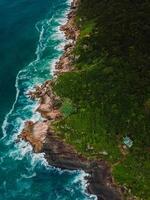 cênico litoral com sozinho casa e pedras com oceano ondas dentro brasil. aéreo Visão foto