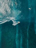 aéreo Visão com surfista equitação em oceano aceno. perfeito ondas com surfistas dentro oceano foto