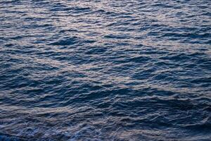 pequeno ondas em a Mediterrâneo mar durante pôr do sol foto