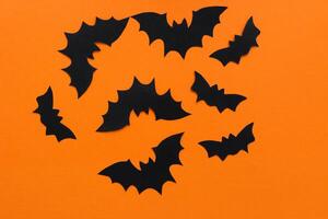 papel morcegos em a laranja fundo, dia das Bruxas conceito foto