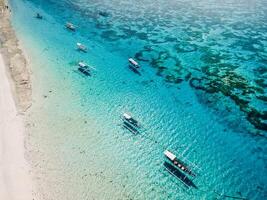 barcos dentro oceano e de praia com branco areia em paraíso ilha. aéreo visualizar. foto