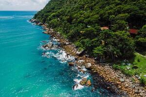 cênico litoral com rochas, árvores e azul oceano dentro brasil. aéreo Visão foto